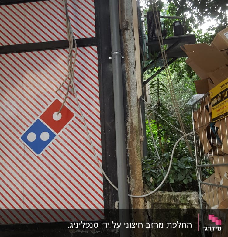 לוגו דומינוס על קיר עם צינורות וחוטים